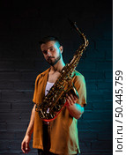 handsome male musician holding saxophone. Стоковое фото, агентство Ingram Publishing / Фотобанк Лори