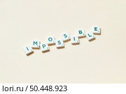 Impossible word formed of scrabble tiles on beige background. Simple creative backdrop for business presentation.. Impossible formed of scrabble tiles on beige background. Стоковое фото, агентство Ingram Publishing / Фотобанк Лори