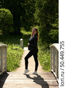 Woman Poses Confidently on Wooden Bridge in Summer Saint Petersburg Park. Стоковое фото, фотограф Aleksandr Golubev / Фотобанк Лори