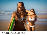 Best friends enjoying the summer, running on the beach with a surfboard. Стоковое фото, агентство Ingram Publishing / Фотобанк Лори