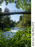 View from under the bridge of white foam pollutants swirling across the water surface floating on river Caima, Palmaz - Oliveira de Azemeis - Portugal. Стоковое фото, агентство Ingram Publishing / Фотобанк Лори