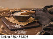 Basmati rice in ceramic bowl with wooden scoop on rustic countertop. Стоковое фото, агентство Ingram Publishing / Фотобанк Лори