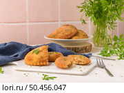 Meat patties and parsley leaves on white ceramic dishes in a kitchen counter top. Стоковое фото, агентство Ingram Publishing / Фотобанк Лори