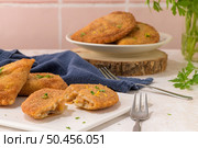 Meat patties and parsley leaves on white ceramic dishes in a kitchen counter top. Стоковое фото, агентство Ingram Publishing / Фотобанк Лори
