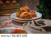 Rabanadas poveiras with sugar and cinnamon and some pomegranate seeds on a rustic kitchen countertop during the Christmas season. Стоковое фото, агентство Ingram Publishing / Фотобанк Лори