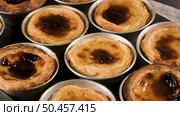 Rows of freshly cooked egg tarts, traditional portuguese dessert, pastel de nata, custard tarts on metal tray. Стоковое фото, агентство Ingram Publishing / Фотобанк Лори