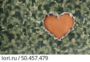 Military Hero love as wartime camouflage fabric with a heart shape hole representing respect for warrior heroes defending freedom and care for wounded soldiers in a 3D illustration style. Стоковое фото, агентство Ingram Publishing / Фотобанк Лори