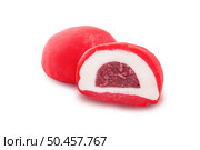 Japanese red mochi dessert with white layer and berry filling inside, cut in half on white background. Sweet traditional treat captured in minimalist food style. Стоковое фото, фотограф Aleksandr Gavrilychev / Фотобанк Лори