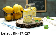Lemon and lime slices in jars and straws in summer wooden background. Стоковое фото, агентство Ingram Publishing / Фотобанк Лори