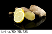 Ginger root drizzler with honey and lemon on black reflective background. Concept of natural ingredients to prevent colds. Стоковое фото, агентство Ingram Publishing / Фотобанк Лори