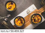 Creme brulee. Bowls with French vanilla cream dessert with caramelised sugar on top, spoons, dark rustic table. Стоковое фото, агентство Ingram Publishing / Фотобанк Лори