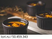 Creme brulee. Bowls with French vanilla cream dessert with caramelised sugar on top, spoons, dark rustic table. Стоковое фото, агентство Ingram Publishing / Фотобанк Лори