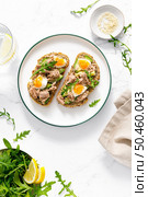 Tuna toast. Open sandwiches with whole grain bread, canned tuna, boiled egg, avocado and arugula. Top view. Стоковое фото, агентство Ingram Publishing / Фотобанк Лори