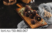 Dark chocolate truffles with hazelnuts over wooden cutting board. Стоковое фото, агентство Ingram Publishing / Фотобанк Лори