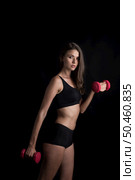 Portrait of young beautiful woman making physical exercises with dumbbells. Стоковое фото, агентство Ingram Publishing / Фотобанк Лори