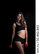 Portrait of young beautiful woman making physical exercises with dumbbells. Стоковое фото, агентство Ingram Publishing / Фотобанк Лори