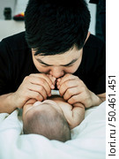 A young Asian father is sniffing his newborn baby. Стоковое фото, агентство Ingram Publishing / Фотобанк Лори