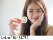 Young woman holding condom prevent pregnancy and Sexually transmitted diseases. Стоковое фото, агентство Ingram Publishing / Фотобанк Лори