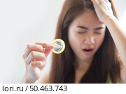 Young woman holding condom prevent pregnancy and Sexually transmitted diseases. Стоковое фото, агентство Ingram Publishing / Фотобанк Лори