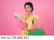 Young fashion woman hand holding wallet and shopping bags. Стоковое фото, агентство Ingram Publishing / Фотобанк Лори