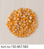 Top view of circle of corn against beige vinyl background. Стоковое фото, агентство Ingram Publishing / Фотобанк Лори