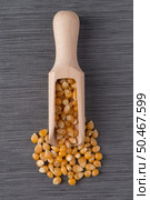 Top view of wooden scoop with corn against grey vinyl background. Стоковое фото, агентство Ingram Publishing / Фотобанк Лори