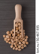 Top view of wooden scoop with chickpeas against grey vinyl background. Стоковое фото, агентство Ingram Publishing / Фотобанк Лори