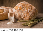 Rustic bread and wheat on an old vintage planked wood table. Стоковое фото, агентство Ingram Publishing / Фотобанк Лори