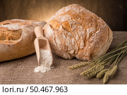 Rustic bread and wheat on an old vintage planked wood table. Стоковое фото, агентство Ingram Publishing / Фотобанк Лори