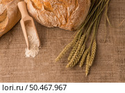 Rustic bread and wheat on an old vintage planked wood table. Стоковое фото, агентство Ingram Publishing / Фотобанк Лори