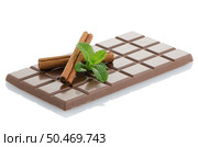 Chocolate bar, mint leaves and cinnamon sticks isolated on white background. Стоковое фото, агентство Ingram Publishing / Фотобанк Лори