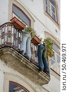 COIMBRA, PORTUGAL ? CIRCA 2012: Modern recycled jeans vase with plants on a balcony of a residential window building Circa 2012 in Coimbra. Стоковое фото, агентство Ingram Publishing / Фотобанк Лори