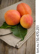 Apricots with leaves on the wooden table. Стоковое фото, агентство Ingram Publishing / Фотобанк Лори