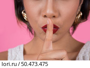 Beauty asian woman red lips and finger showing hush silence sign. Стоковое фото, агентство Ingram Publishing / Фотобанк Лори