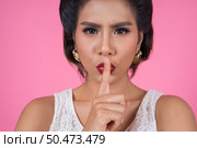 Beauty asian woman red lips and finger showing hush silence sign. Стоковое фото, агентство Ingram Publishing / Фотобанк Лори