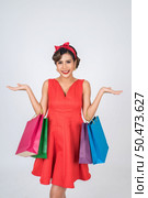 Beautiful asian woman holding colored shopping bags. Стоковое фото, агентство Ingram Publishing / Фотобанк Лори