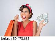 Beautiful asian woman holding colored shopping bags. Стоковое фото, агентство Ingram Publishing / Фотобанк Лори