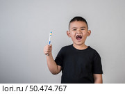 Little boy brushing his teeth in studio photo. Стоковое фото, агентство Ingram Publishing / Фотобанк Лори
