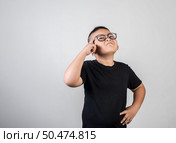 Funny Genius boy Thinking in studio shot. Стоковое фото, агентство Ingram Publishing / Фотобанк Лори