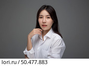 The woman wore a white shirt and raised her right hand. Стоковое фото, агентство Ingram Publishing / Фотобанк Лори