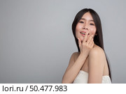 The woman wore a white strapless dress and hand touched her mouth. Стоковое фото, агентство Ingram Publishing / Фотобанк Лори