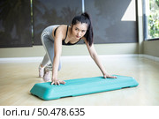 The girl pushed up with steps platform in the gym. Стоковое фото, агентство Ingram Publishing / Фотобанк Лори