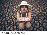 The woman sat looking at the sky and asked for rain in the dry weather,global warming. Стоковое фото, агентство Ingram Publishing / Фотобанк Лори