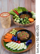 Chili paste paste in a bowl with eggplant, carrots, chili, cucumbers in a basket on wood table. Стоковое фото, агентство Ingram Publishing / Фотобанк Лори