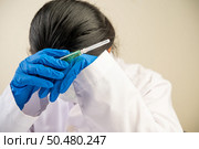 Scientists wear gloves and hold syringes and then bend their heads. Стоковое фото, агентство Ingram Publishing / Фотобанк Лори