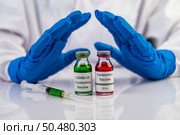 Scientists wear blue gloves and make hands unacceptable vaccine  Selective focus. Стоковое фото, агентство Ingram Publishing / Фотобанк Лори