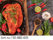 Marinated pork used in cooking, complete with chili peppers Kaffir lime leaves in a black plate. Стоковое фото, агентство Ingram Publishing / Фотобанк Лори