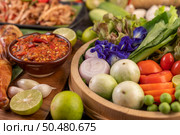 Shallots, eggplants, tomatoes, lemons, garlic, Butterfly pea flowers, chili paste and grilled chicken on wood. Стоковое фото, агентство Ingram Publishing / Фотобанк Лори