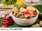 Tom Yum noodle with shrimp and boiled egg, accompanied by lime, cucumber, basil, eggplant and garlic. Стоковое фото, агентство Ingram Publishing / Фотобанк Лори