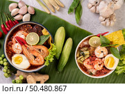 Tom Yum noodle with shrimp and boiled egg, accompanied by lime, cucumber, basil, eggplant and garlic. Стоковое фото, агентство Ingram Publishing / Фотобанк Лори